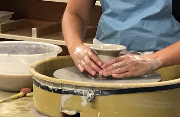 Using a potters wheel to create a piece of pottery